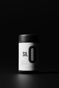 Sleek black and white photo of the ChefCutz pomade jar on a minimalist surface.