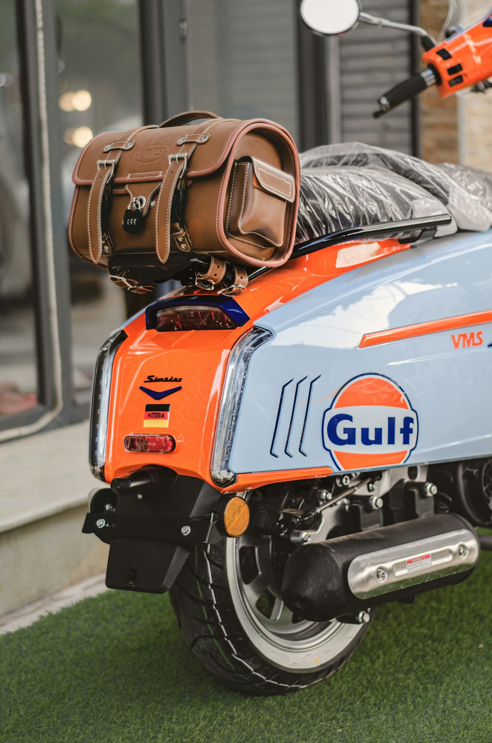 an orange and blue motorcycle with luggage on the back