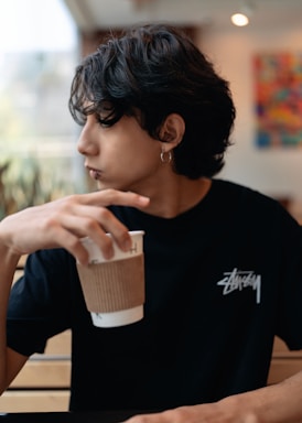A casual scene of someone grabbing coffee, dressed in a soft cotton tee that subtly speaks volumes about their identity.