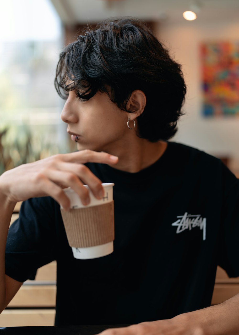 a person sitting at a table with a cup of coffee