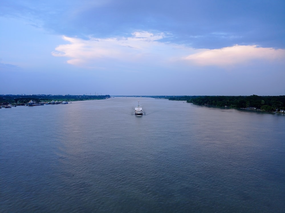 Un bateau est au milieu d’un grand plan d’eau