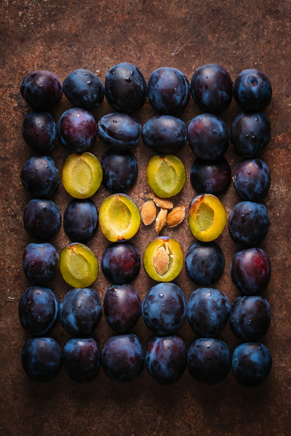 a bunch of plums and a lemon on a table