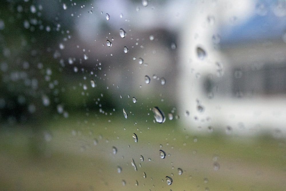 rain drops on a window with a house in the background