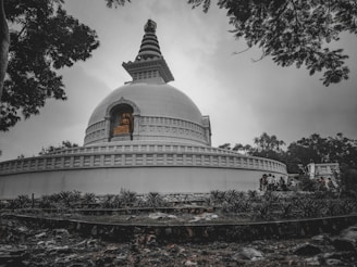 a large white building sitting under a cloudy sky