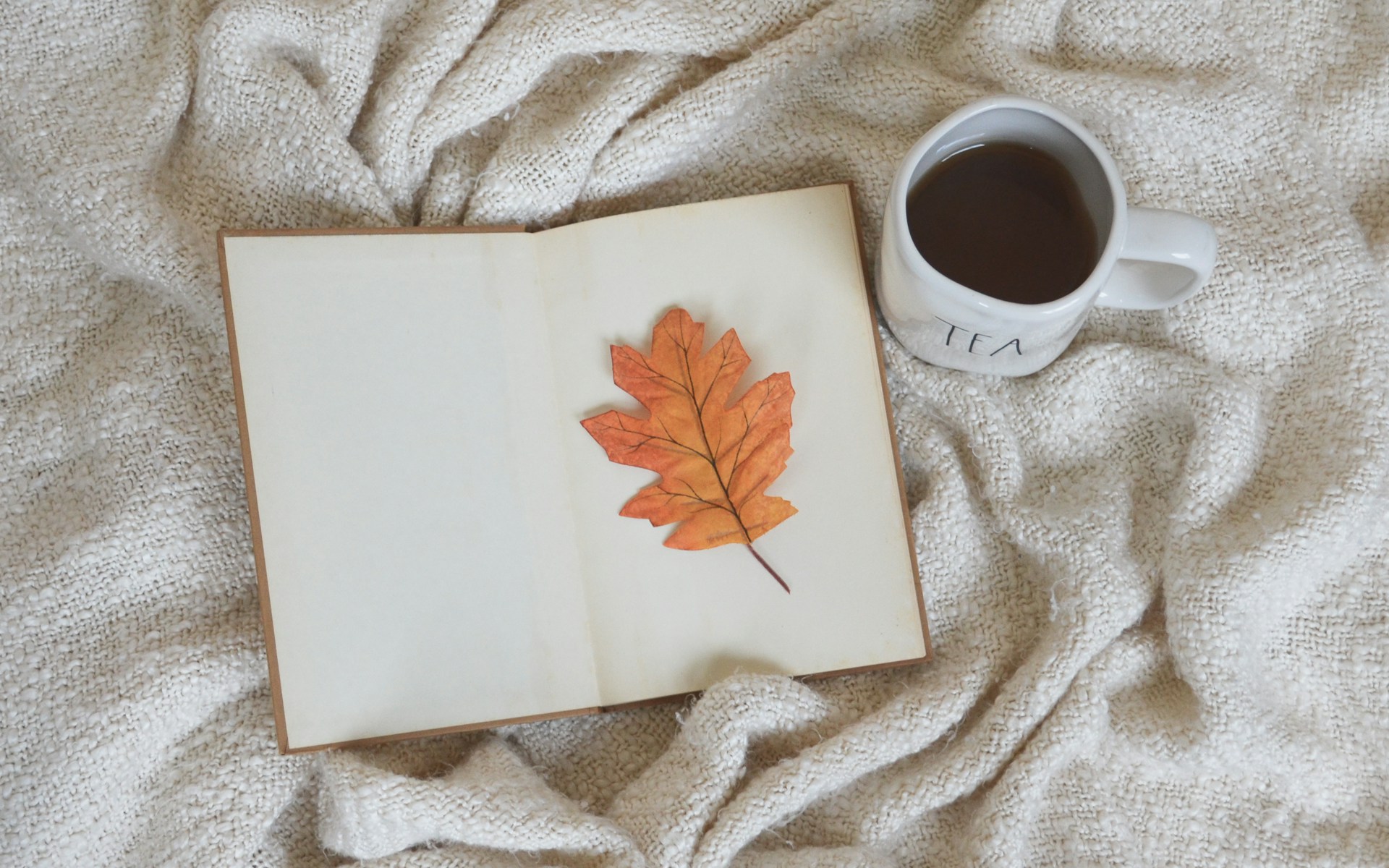 a cup of coffee and a book on a bed