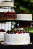 A vibrant berry-topped vanilla cake with clean lines and fresh fruit accents.
