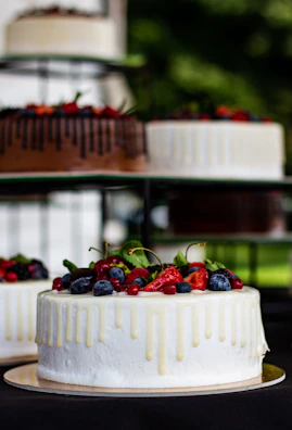 A vibrant berry-topped vanilla cake with clean lines and fresh fruit accents.