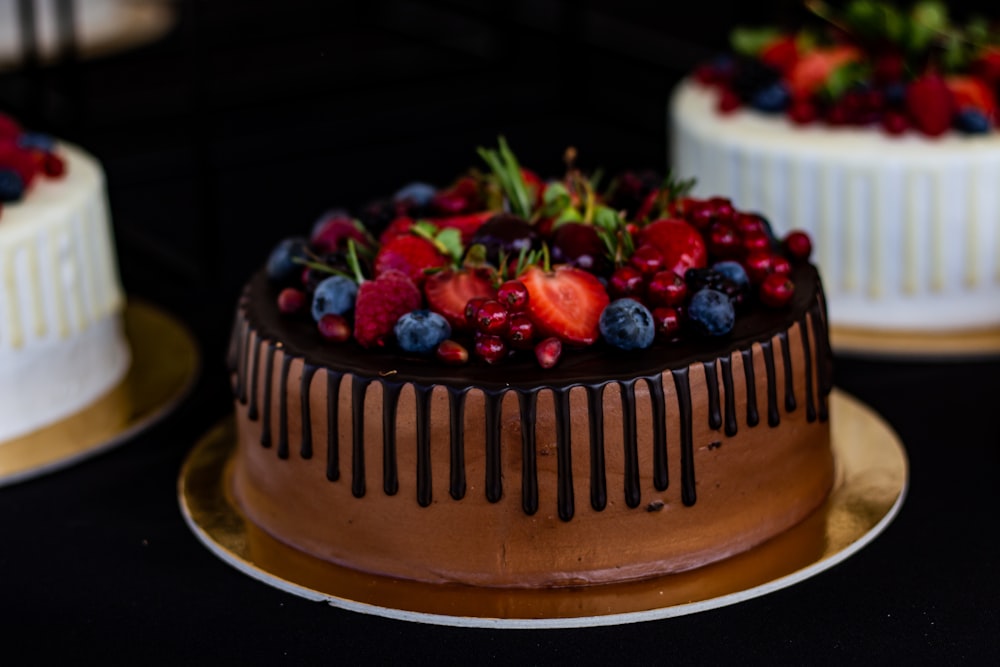 a chocolate cake topped with berries and chocolate icing