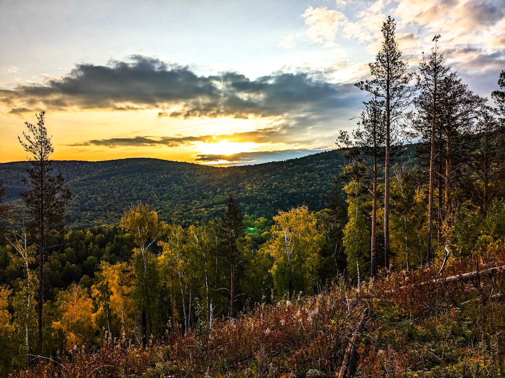 the sun is setting over the mountains in the distance