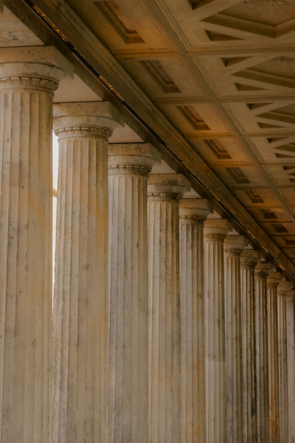 a row of white pillars under a bridge