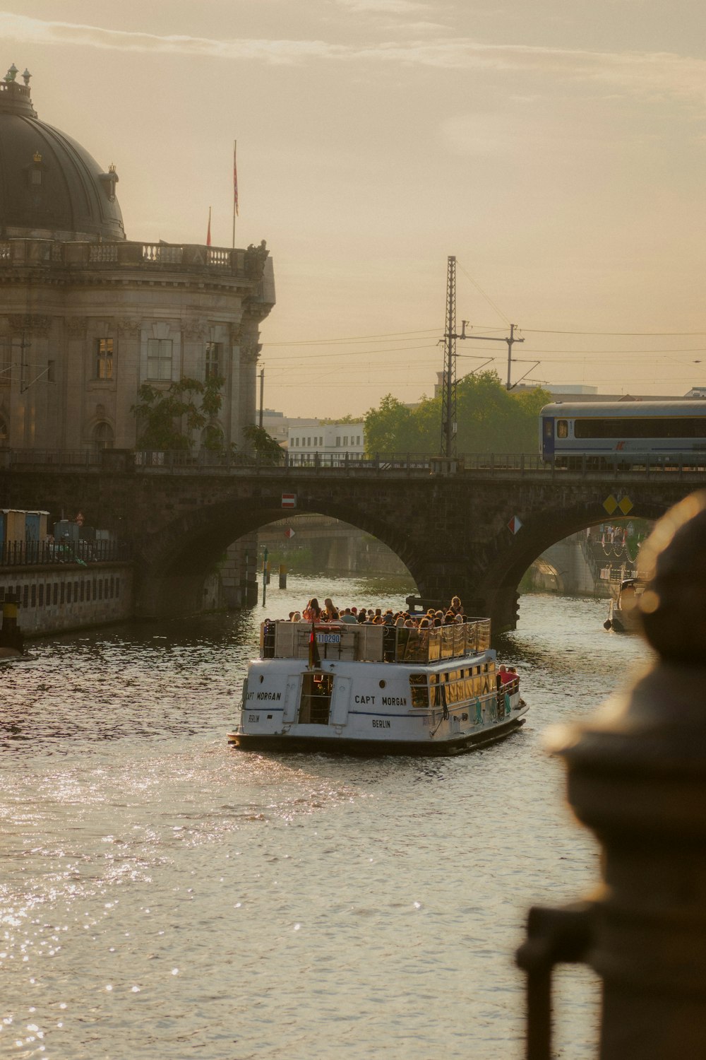 a boat is traveling down a river with a bridge in the background