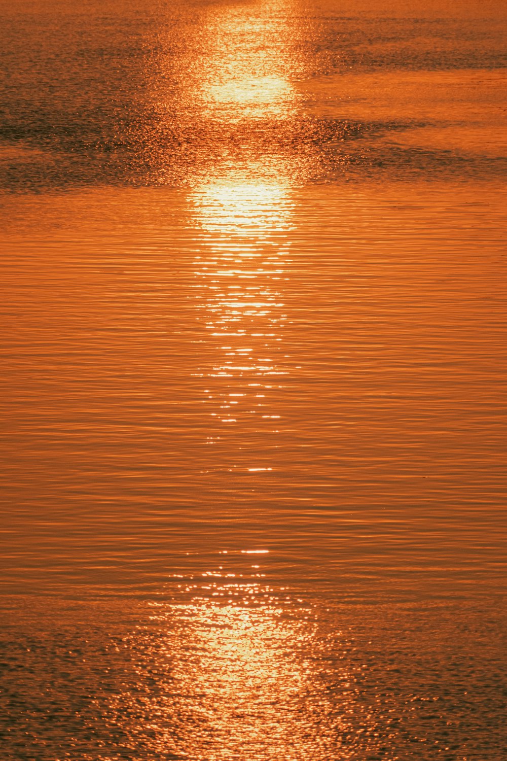 the sun is setting over the water of a lake