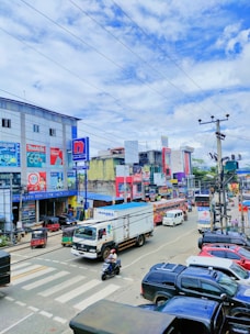 a city street filled with lots of traffic next to tall buildings