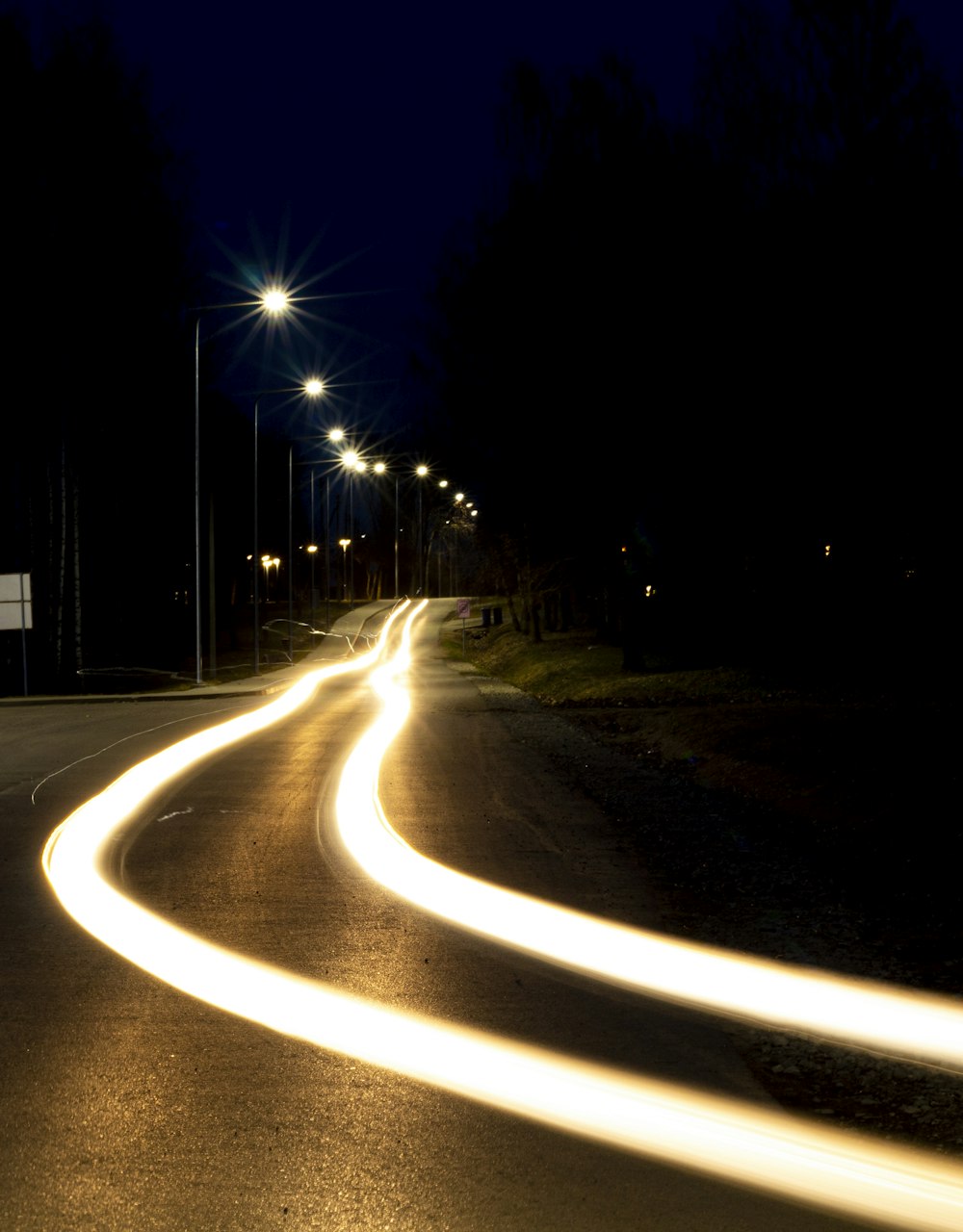 a curved road at night with street lights