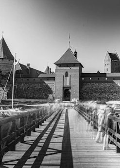 A haunting black-and-white still from a 1960s gothic horror film featuring eerie shadows and an ancient castle.