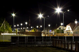 Nighttime surveillance with a guard patrolling a residential area under red and black lighting