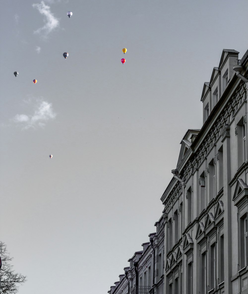 a group of kites flying in the sky above a building