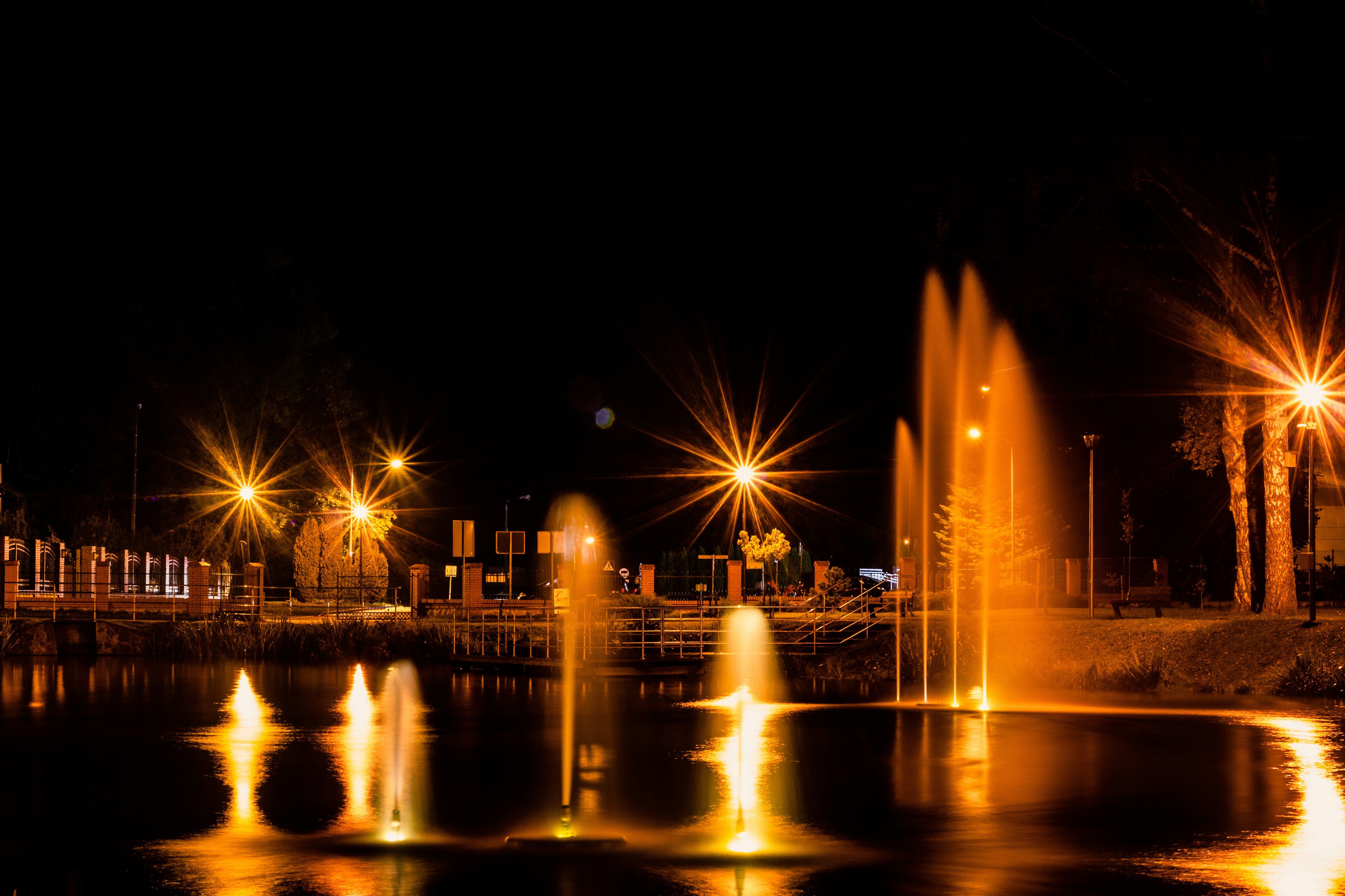 a night scene with a fountain and lights, 