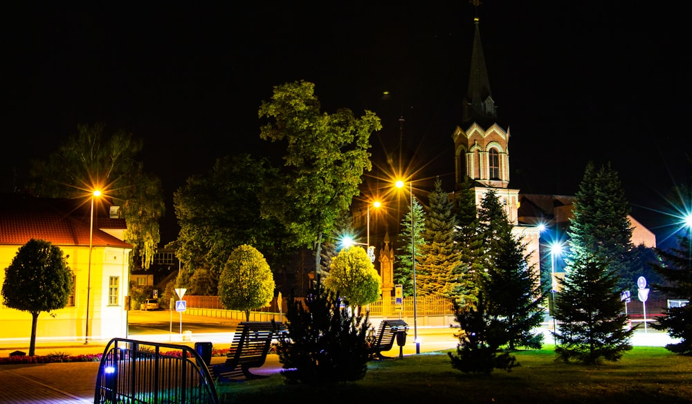 Una vista nocturna de una ciudad con una iglesia al fondo