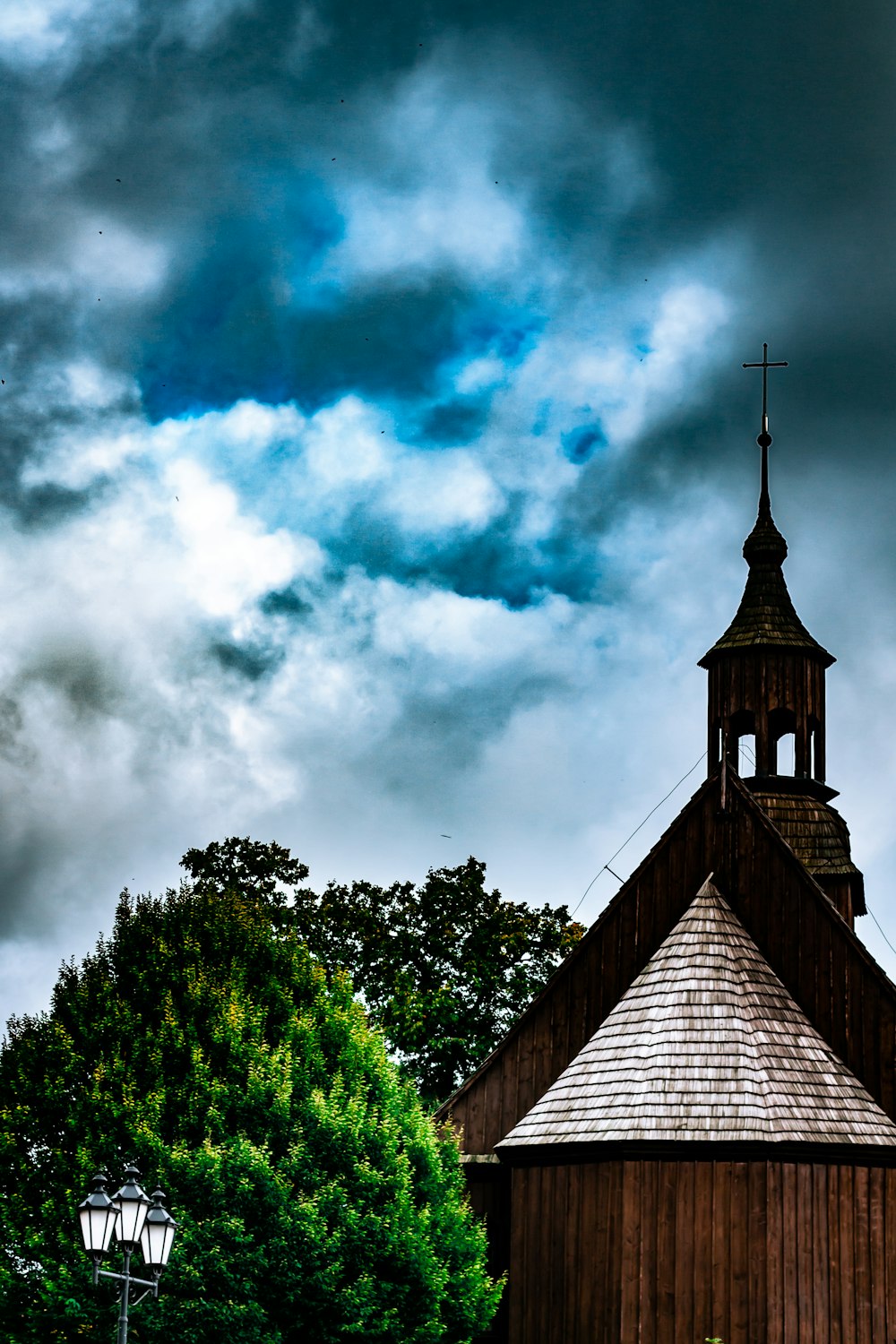 a wooden building with a steeple under a cloudy sky