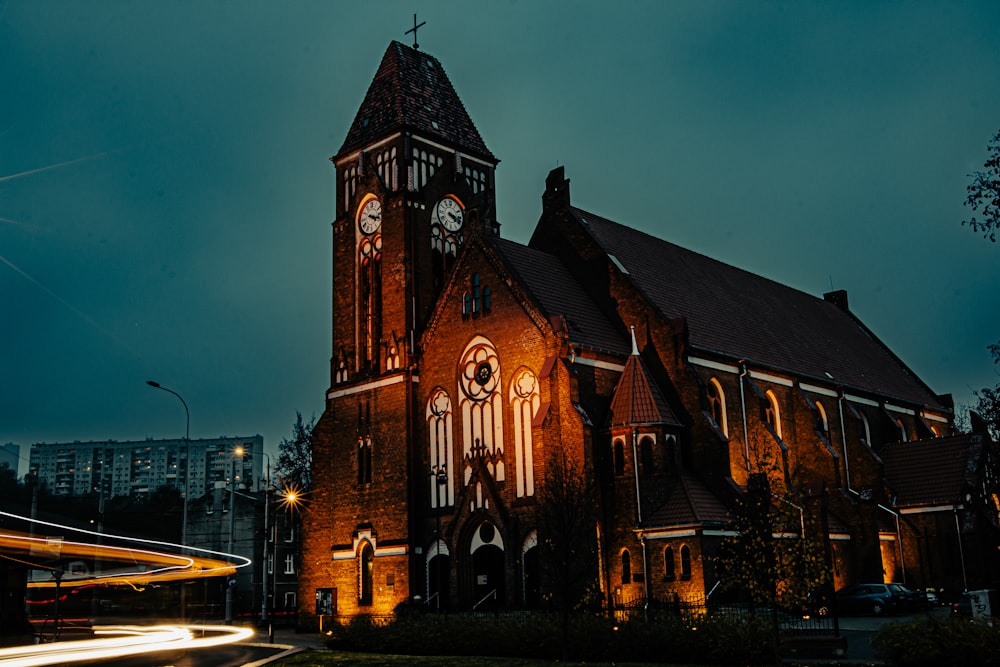 Una chiesa con una torre dell'orologio illuminata di notte