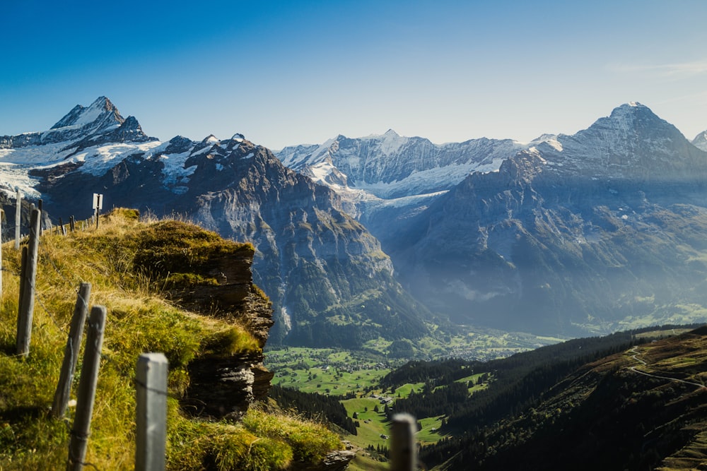 a view of a mountain range with a fence in the foreground