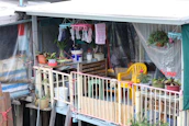 Bright balcony decorated with bohemian cushions and potted plants.