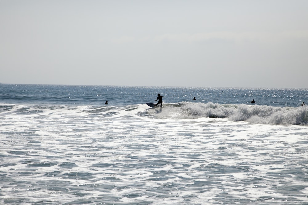 a man riding a wave on top of a surfboard