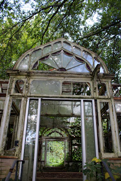 The old greenhouse at Struan, surrounded by wildflowers and garden tools.