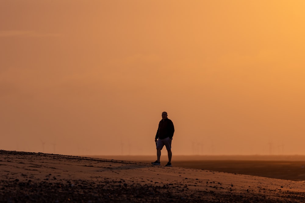 um homem em cima de uma praia de areia
