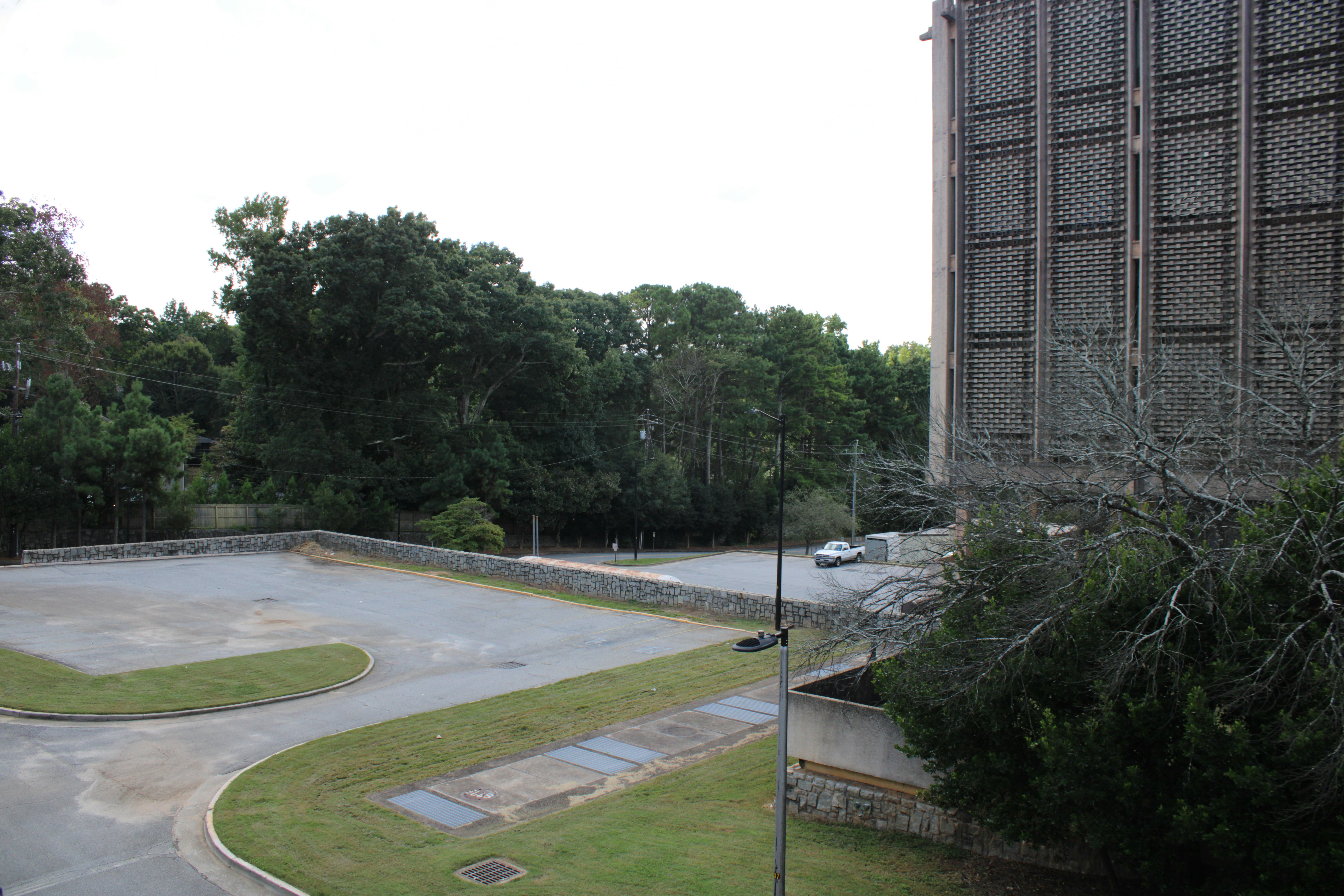 an empty parking lot next to a tall building