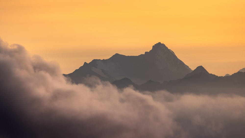 uma vista de uma montanha com nuvens em primeiro plano
