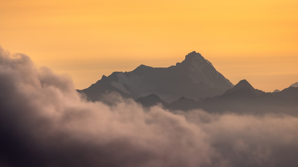 Una vista de una montaña con nubes en primer plano