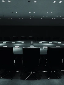 Minimalist boardroom scene with executives reviewing cross-border market maps under soft lighting.