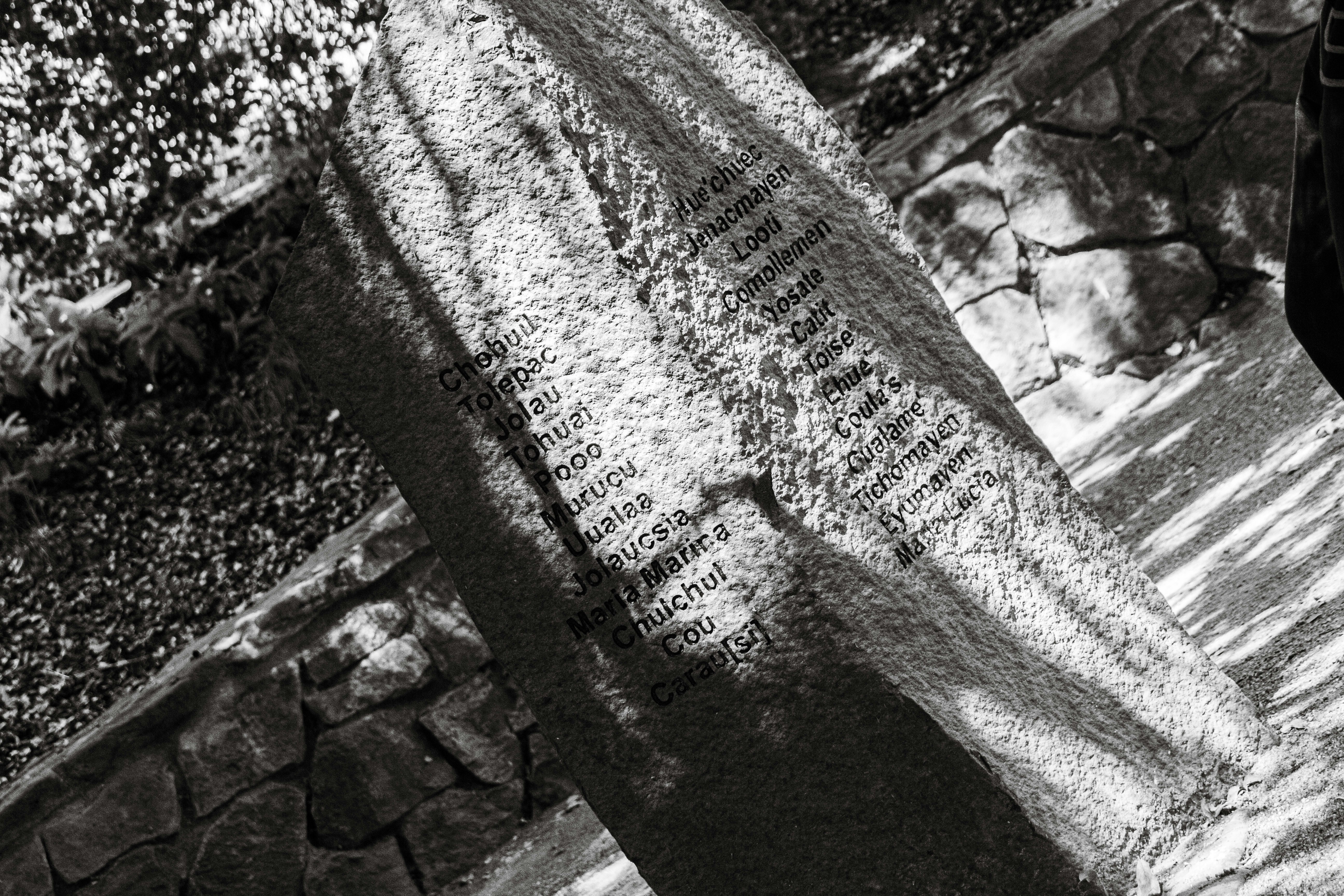 a black and white photo of a person standing next to a sign