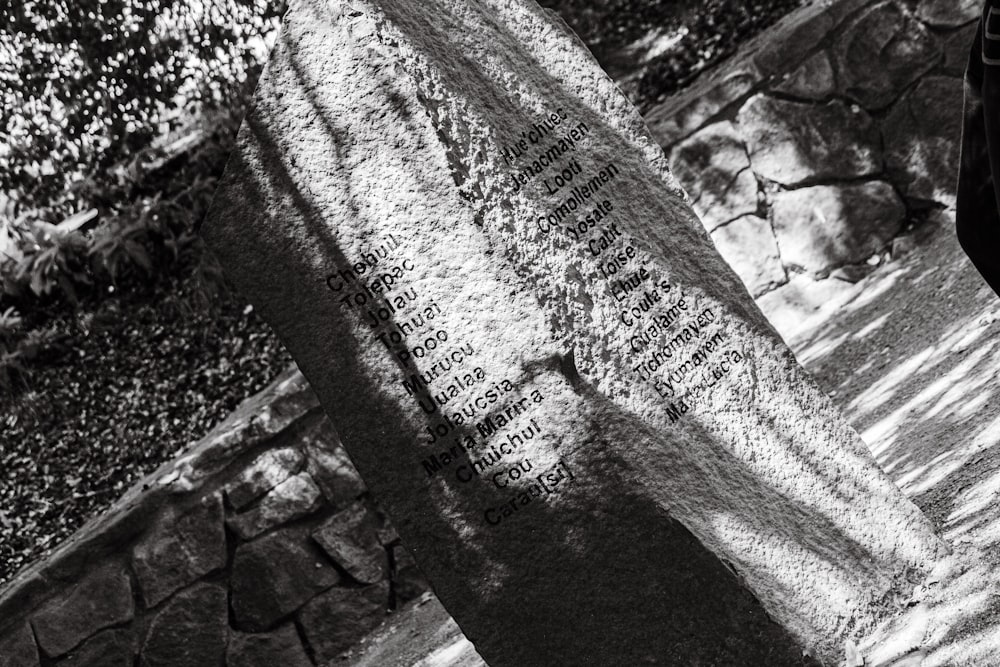 a black and white photo of a person standing next to a sign