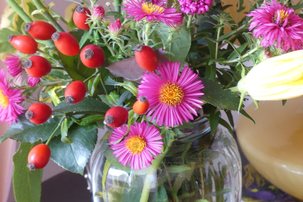 a vase filled with lots of flowers on top of a table