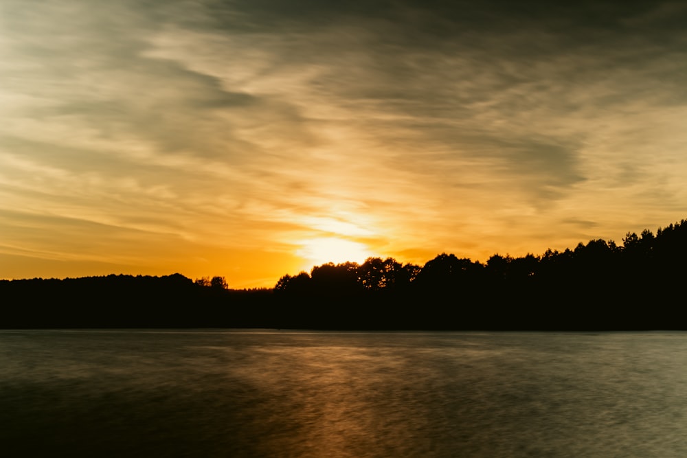 Die Sonne geht über einem Gewässer unter