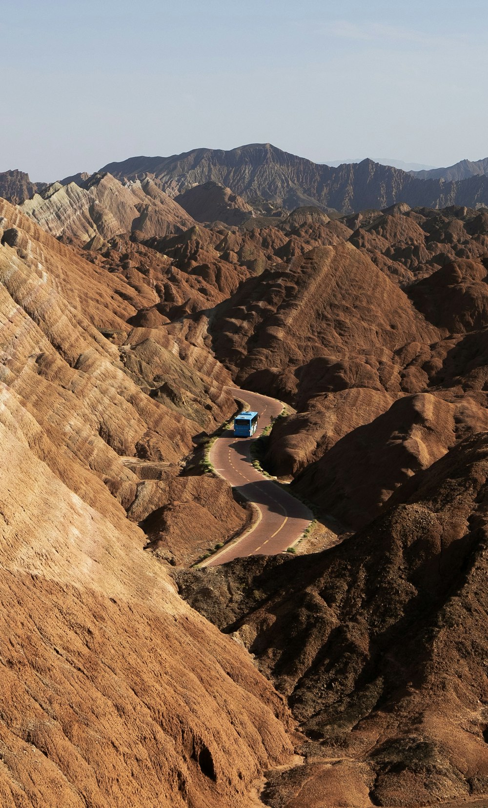 a truck driving down a winding road in the mountains