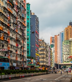 A busy Sims city street with colorful buildings and Sims walking around.