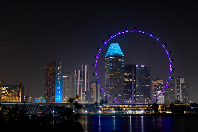 Aerial night view of Balneário Camboriú with neon blue lights highlighting the cityscape and the FG Big Wheel.