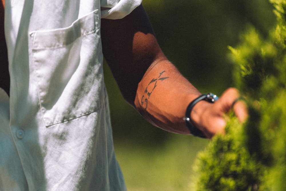 a man with a cross tattoo on his arm