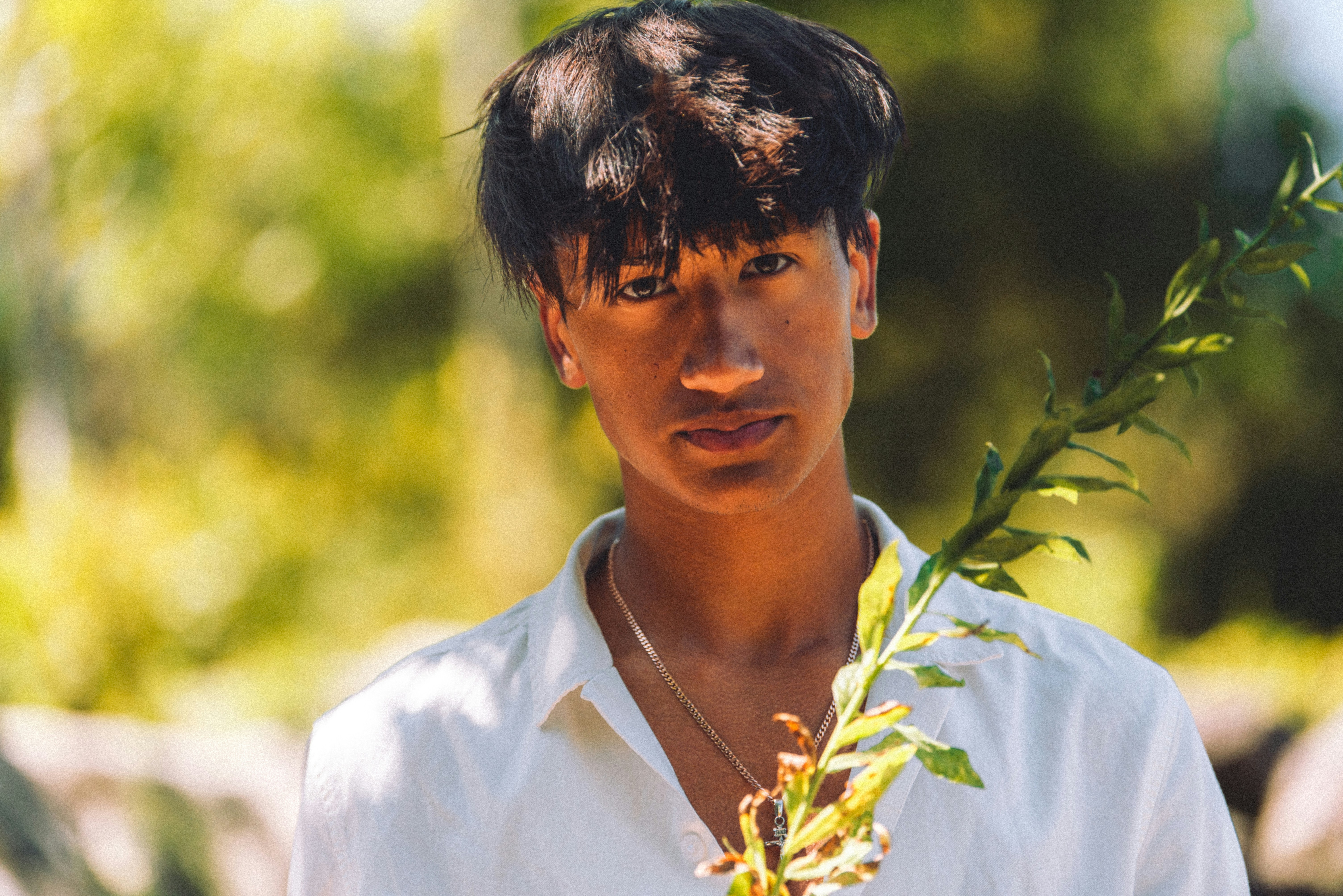 a young man holding a plant in his hand