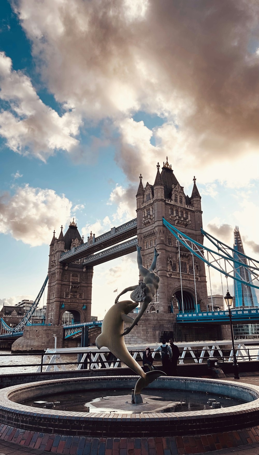 a statue in front of the tower bridge