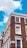 A corner of a brick building with multiple white-framed windows. The building features a classic architectural style with detailed cornices. A street sign on the building indicates 'Craven Road W2, City of Westminster.' The sky is a vibrant blue with a few white clouds.