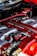 Close-up view of a high-performance car engine featuring a prominent red-tinted twin turbo system with metallic components and intricate detailing.
