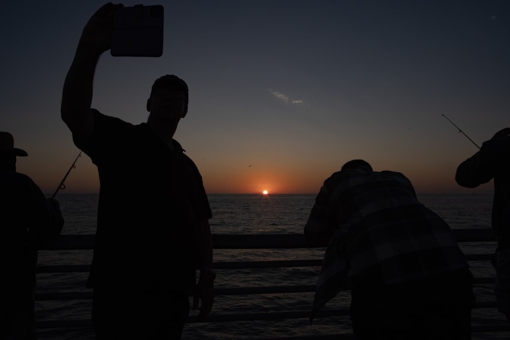 a group of people on a boat watching the sun set