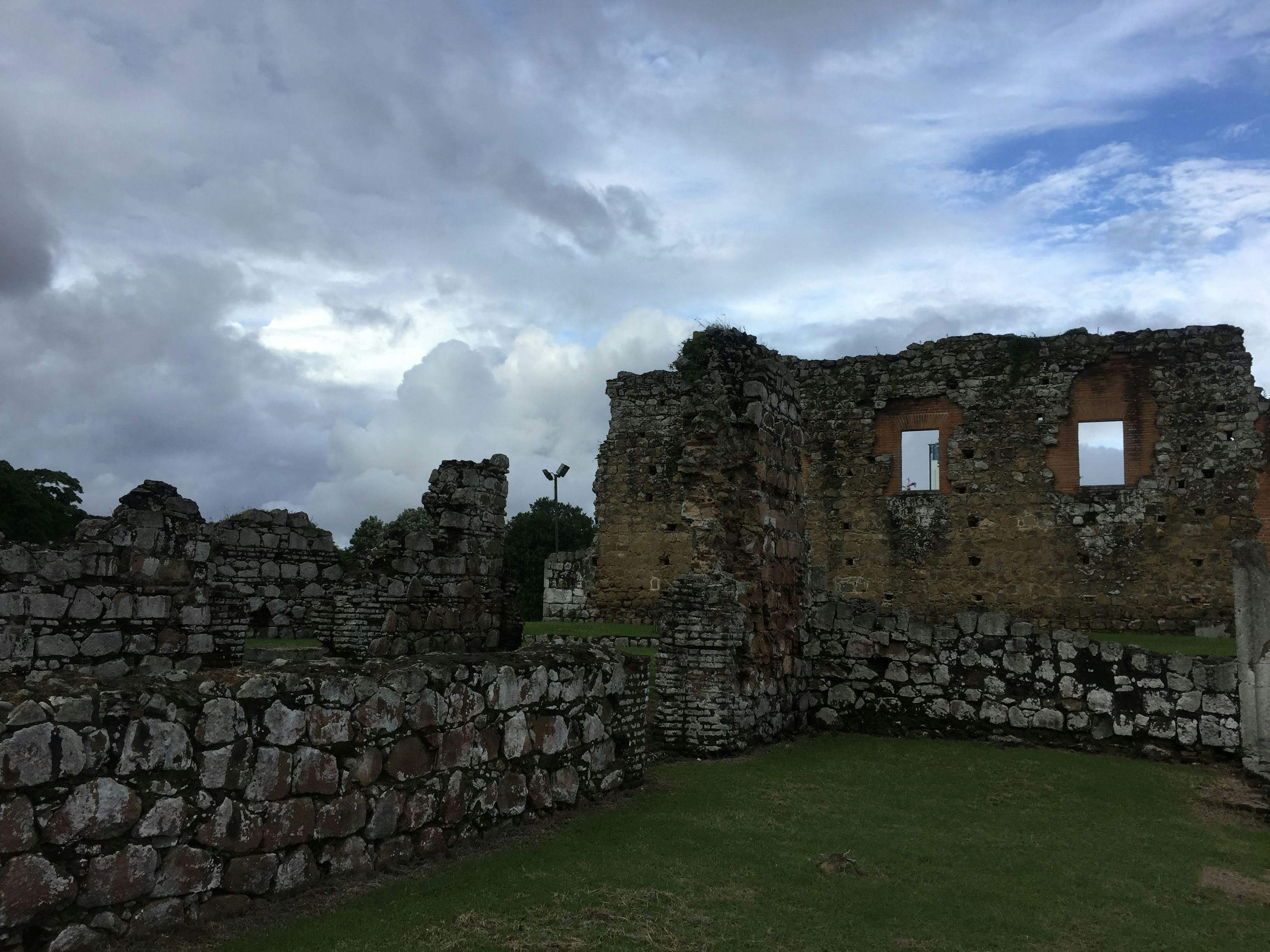 A stone wall with two windows in the middle of it