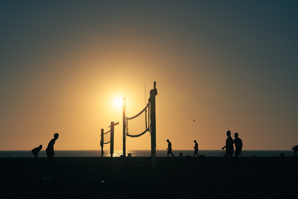 a group of people playing volleyball on the beach