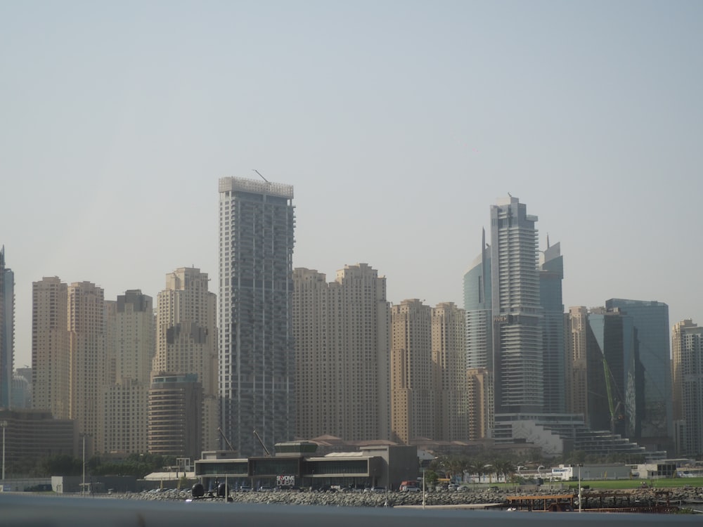 a city skyline with tall buildings and a body of water